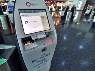 Doha, Katar - 24 numara. 2019. Hamad Uluslararası Havalimanı 'nın kalkış bölgesi. Kişisel hizmet kioskunda bilet yazdırma