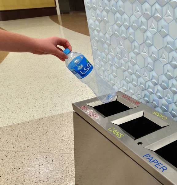 Doha, Qatar - 20 novembre. 2019. La main des enfants met une bouteille en plastique dans un conteneur séparé dans la station de métro Al Bidda — Photo