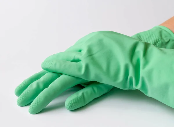 Green latex dishwashing gloves on white background
