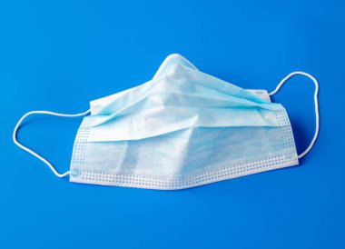 Mavi arka planda kullanılmış tek kullanımlık tıbbi maske