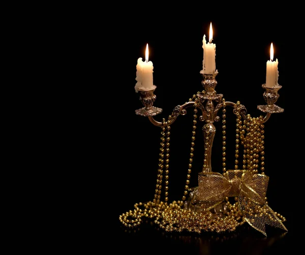 Candelabro vintage con velas encendidas y adornos de Navidad dorados fondo negro . — Foto de Stock