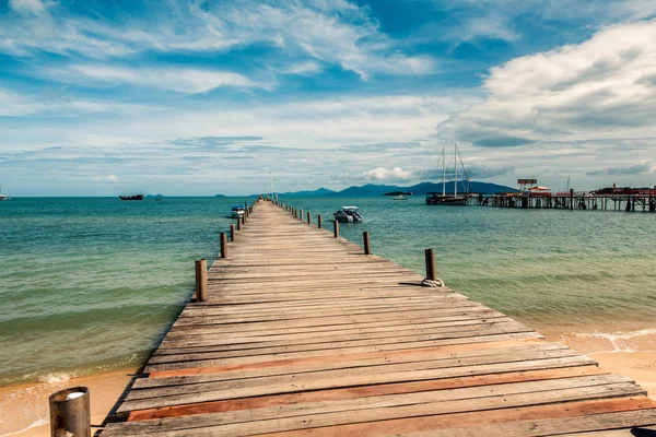 Wooden pier on the sandy shore. — Stock Photo, Image