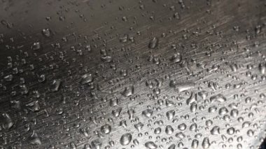 Metal bir yüzeyde yağmur damlaları.