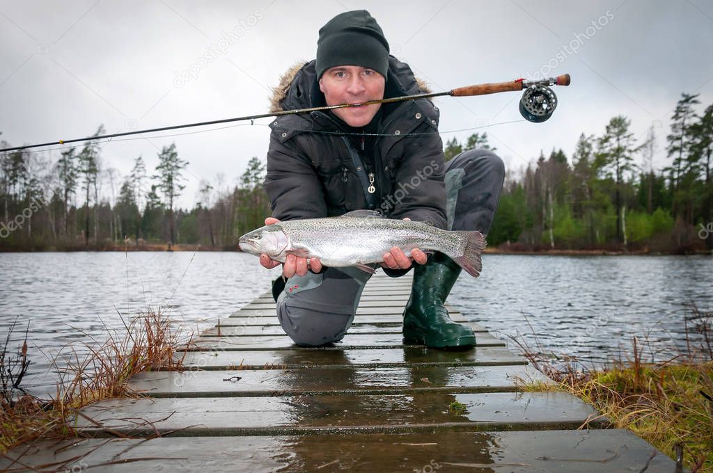 Fly fishing angler presents his trophy fish