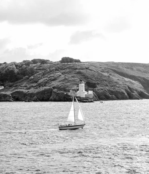 Little sailing boat in front of falmouth light house — Stock Photo, Image