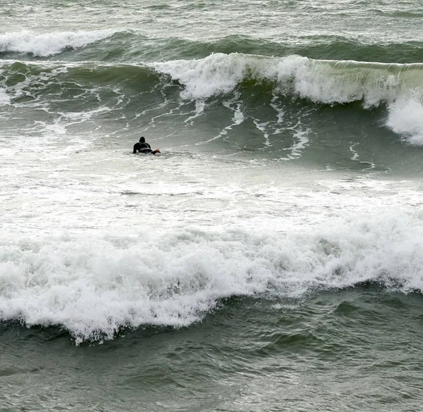Un surfeur surfe sur une vague en italie — Photo