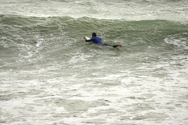 Un surfista surfear una ola en italia — Foto de Stock