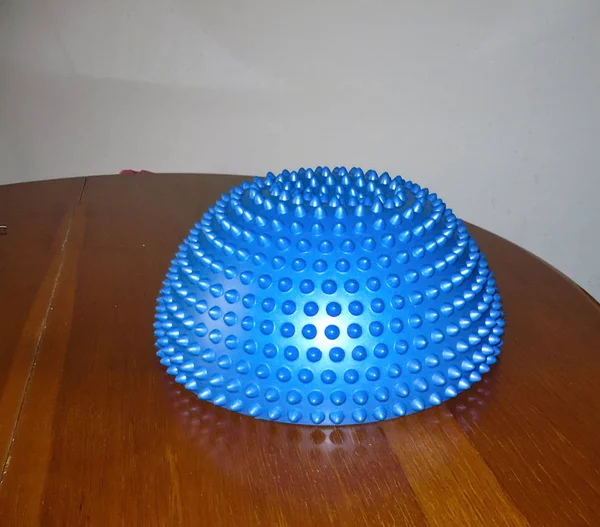 Dettaglio di palla propriocettiva blu sulla parte superiore di un tavolo di legno marrone — Foto Stock