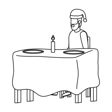 Masasında Noel şapkası olan genç bir adam.