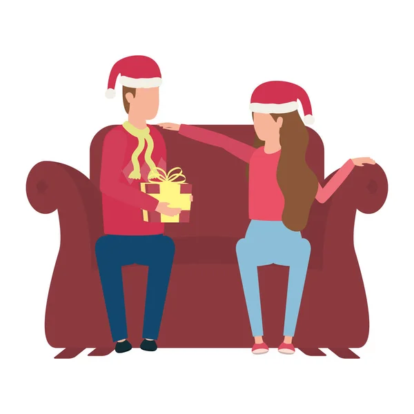 Lovers couple with christmas hat and gift seated in sofa — Stock Vector