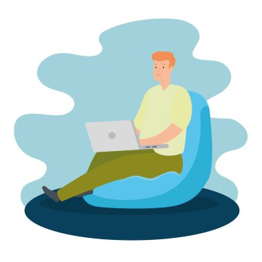 Evde dizüstü bilgisayarı olan bir adam pouf 'ta oturuyor.