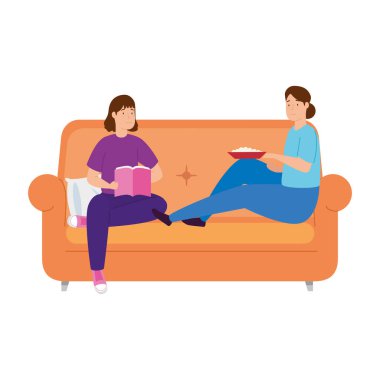 Genç kadınlar kanepede otururlar.