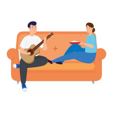 Genç çift oturma odasında yemek yiyor ve gitar çalıyor.