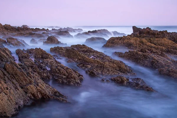 Eau de mer laiteuse au-dessus des rochers sur la côte — Photo