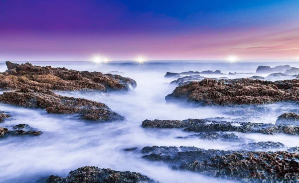 Melkachtig zeewater over rotsen aan de kust — Stockfoto