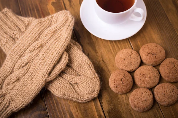 Kaffee, Fäustlinge und Haferkekse auf Holz — Stockfoto