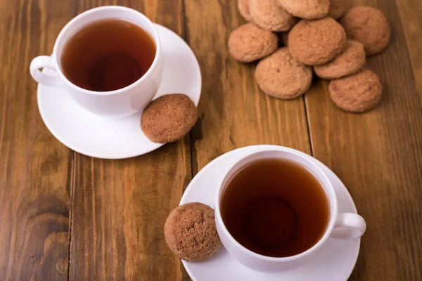 Herbata i ciasteczka owsiane na drewnianym stole — Zdjęcie stockowe