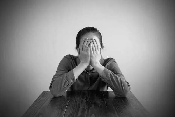 Mulher deprimida sentada a uma mesa — Fotografia de Stock