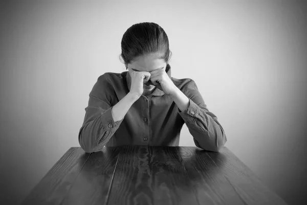 Mujer deprimida sentada en una mesa — Foto de Stock