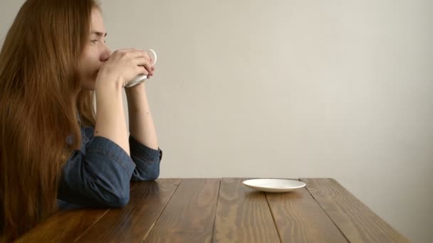 Vrouw koffie drinken op een houten tafel — Stockvideo