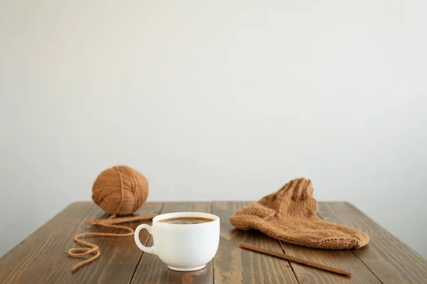 Coffee, woolen sock and knitting on a table — Stock Photo, Image