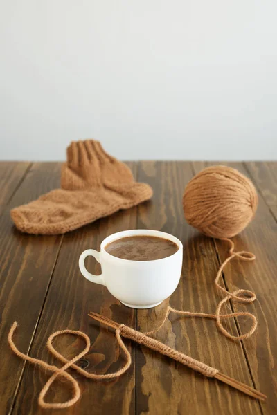 Kaffee, Wollsocken und Stricken auf einem Tisch — Stockfoto