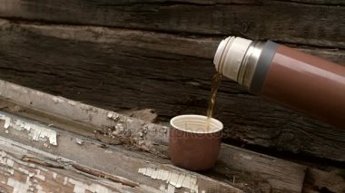 Ahşap arka plan üzerinde kahverengi termos