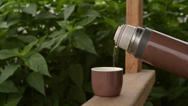 Braune Thermoskanne mit Tee im Freien — Stockvideo