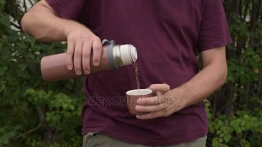 Termos çay fincan içine dökülen adam