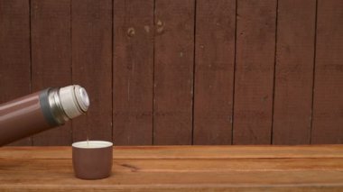 Ahşap arka plan üzerinde çay ile termos