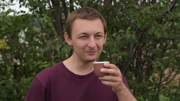 Young man drinking tea outdoors — Stock Video