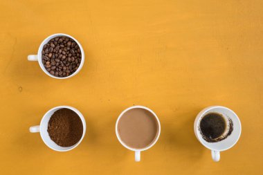 Sarı bir arka plan üzerinde dört farklı bardak