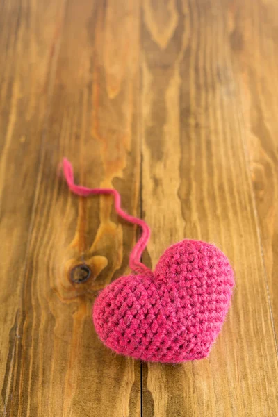 나무 테이블에 대 한 뜨개질된 심장 — 스톡 사진