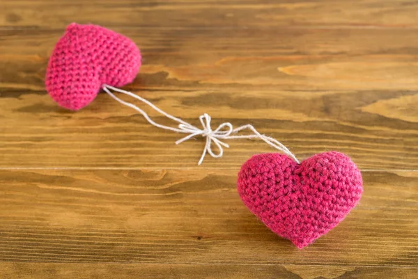 Two crocheted hearts on a wooden table — Stock Photo, Image