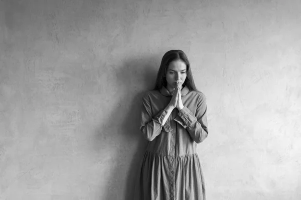 Treurige vrouw stond naast de grunge-muur — Stockfoto