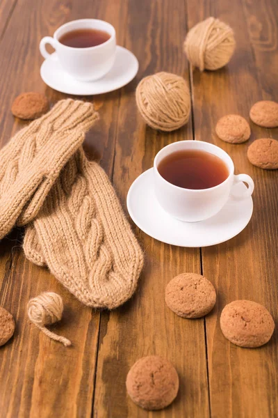 Kawa, rękawiczki i owsiane ciasteczko na drewno — Zdjęcie stockowe