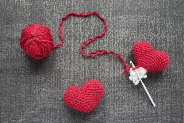 Crocheted red hearts on a grunge board — Stock Photo, Image