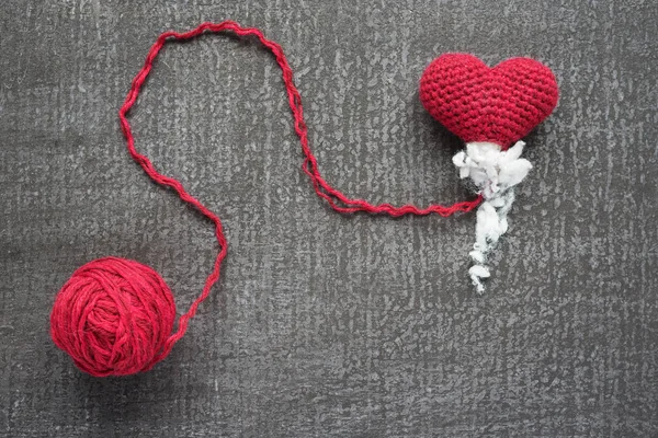 Crocheted red heart on a grunge board — Stock Photo, Image