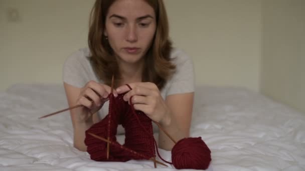 Bella donna che lavora a maglia su un letto — Video Stock