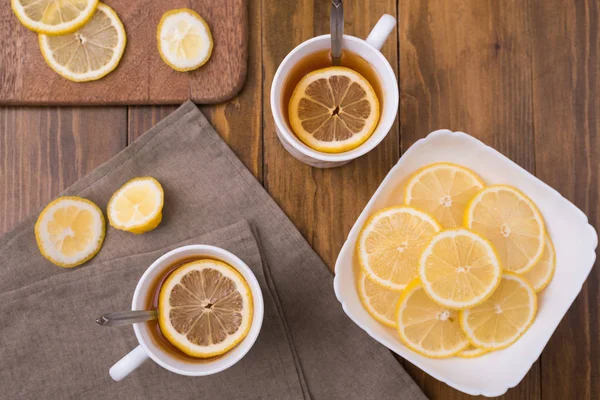Композиция с лимонным чаем на деревянном столе — стоковое фото