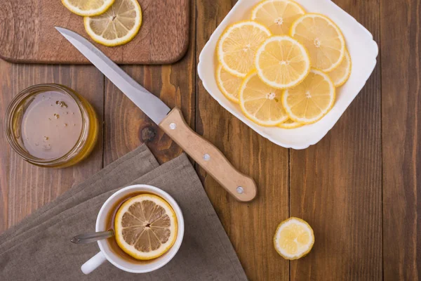 Composición con té de limón sobre una mesa de madera Imagen de archivo