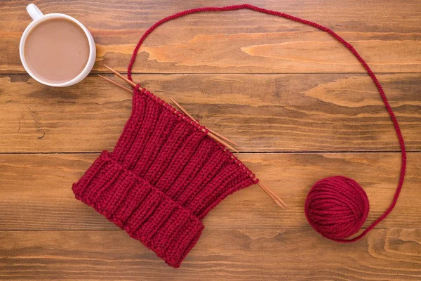 Coffee and red knitting on wooden background — Stock Photo, Image