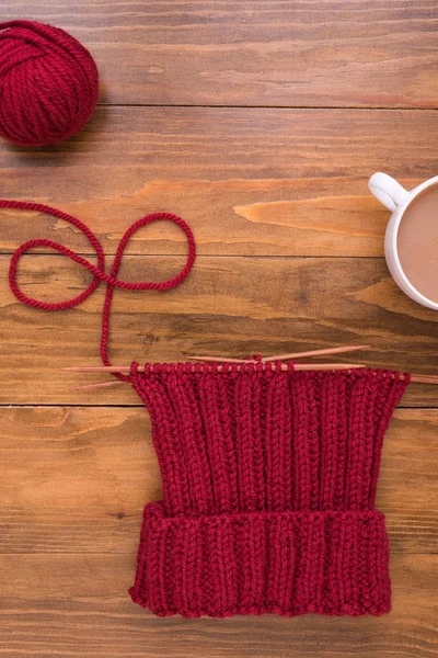 Coffee and red knitting on wooden background — Stock Photo, Image