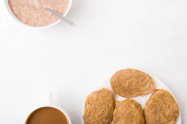 Buñuelos, café y gachas de linaza sobre blanco Imagen de stock