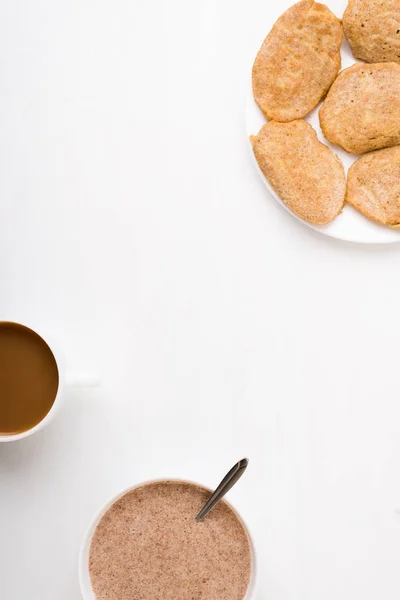 Buñuelos, café y gachas de linaza sobre blanco Imagen de stock