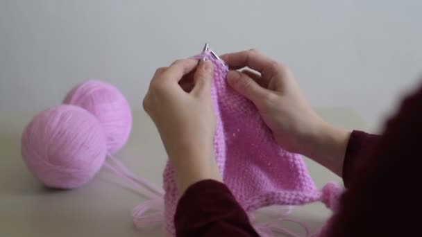 Γυναίκα χέρια πλέξιμο μια ροζ πουλόβερ — Αρχείο Βίντεο