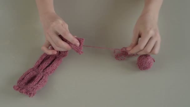 Распутывание розового вязания — стоковое видео