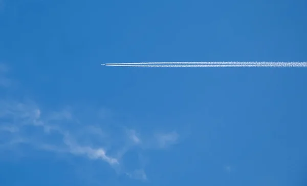 The plane and its torsional track on the background of blue sky. — Stock Photo, Image