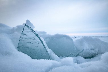 Şeffaf mavi buz kütleleri güneşli bir günde mavi gökyüzüne karşı buz homurdanır. Baykal Gölü 'nün alışılmadık kış manzarası. Doğal soğuk bir geçmişi var. Sibirya, Rusya.
