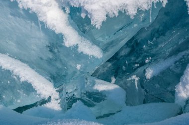 Şeffaf mavi buz kütleleri güneşli bir günde mavi gökyüzüne karşı buz homurdanır. Baykal Gölü 'nün alışılmadık kış manzarası. Doğal soğuk bir geçmişi var. Sibirya, Rusya.